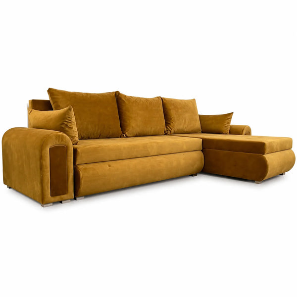 A modern sectional sofa in a rich mustard yellow velvet fabric, featuring a left-facing armrest with an integrated side table, a right-facing chaise lounge, and four matching back cushions, shown against a plain white background.