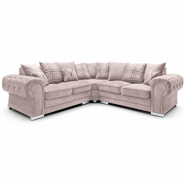 A light blush pink tufted sectional sofa with matching plaid accent pillows, shown on a clean white background.